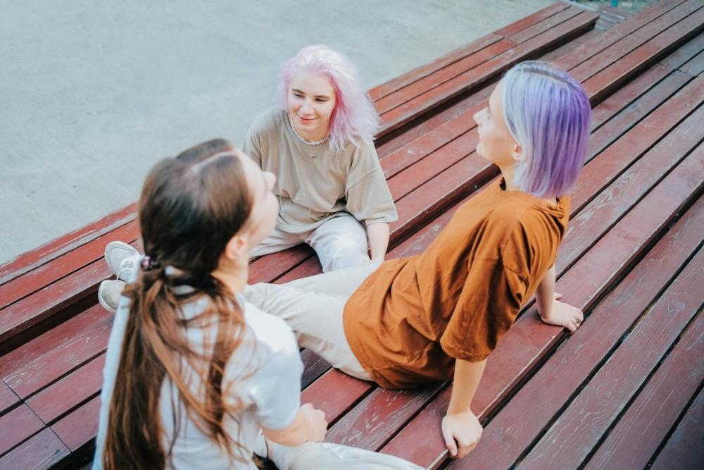 Drei junge Frauen auf einem Date in einem Park in Berlin