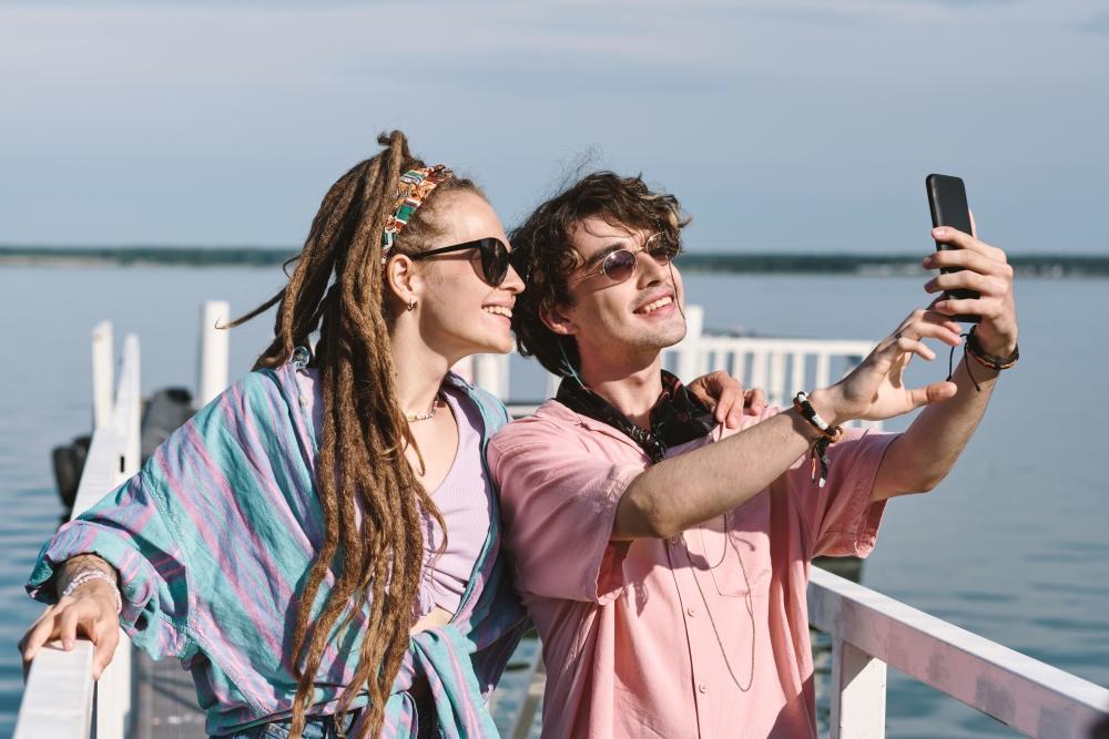 Summer_Fling_Was_wenn_doch_mehr_aus_deinem_summer_Fling_wird_Paar_auf_einem_steg_im_Wasser_macht_ein_foto.jpg