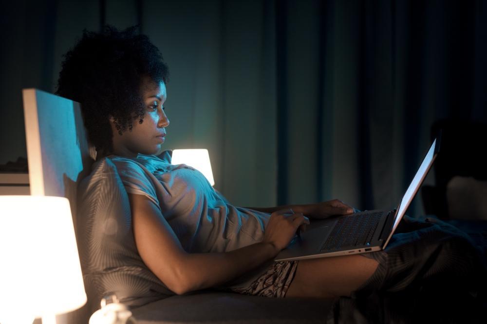 frau_schreibt_erotische_geschichte_am_Laptop_in_ihrem_bett_