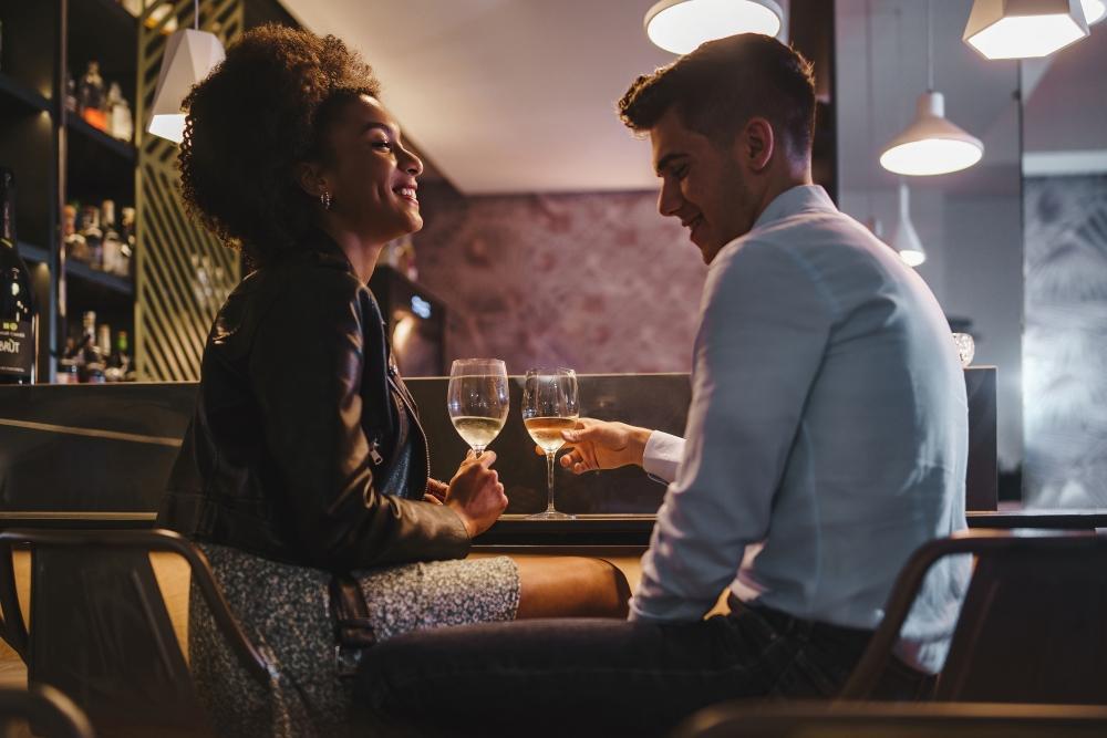 sex_codes_sind_nicht_das_selbe_wie_datingkultur_frau_und_mann_lachend_in_einer_bar_beim_ersten_date_